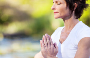 mulher meditando em meio a mudanças psicológicas da menopausa.