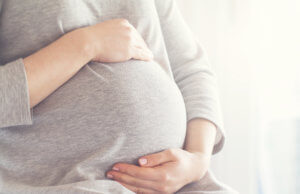Saiba diferenciar os sintomas da gravidez e da menopausa Mulher grávida que pode ter sintomas semelhantes ao da menopausa